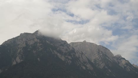 timelapse of clouds going through the top of the mountain