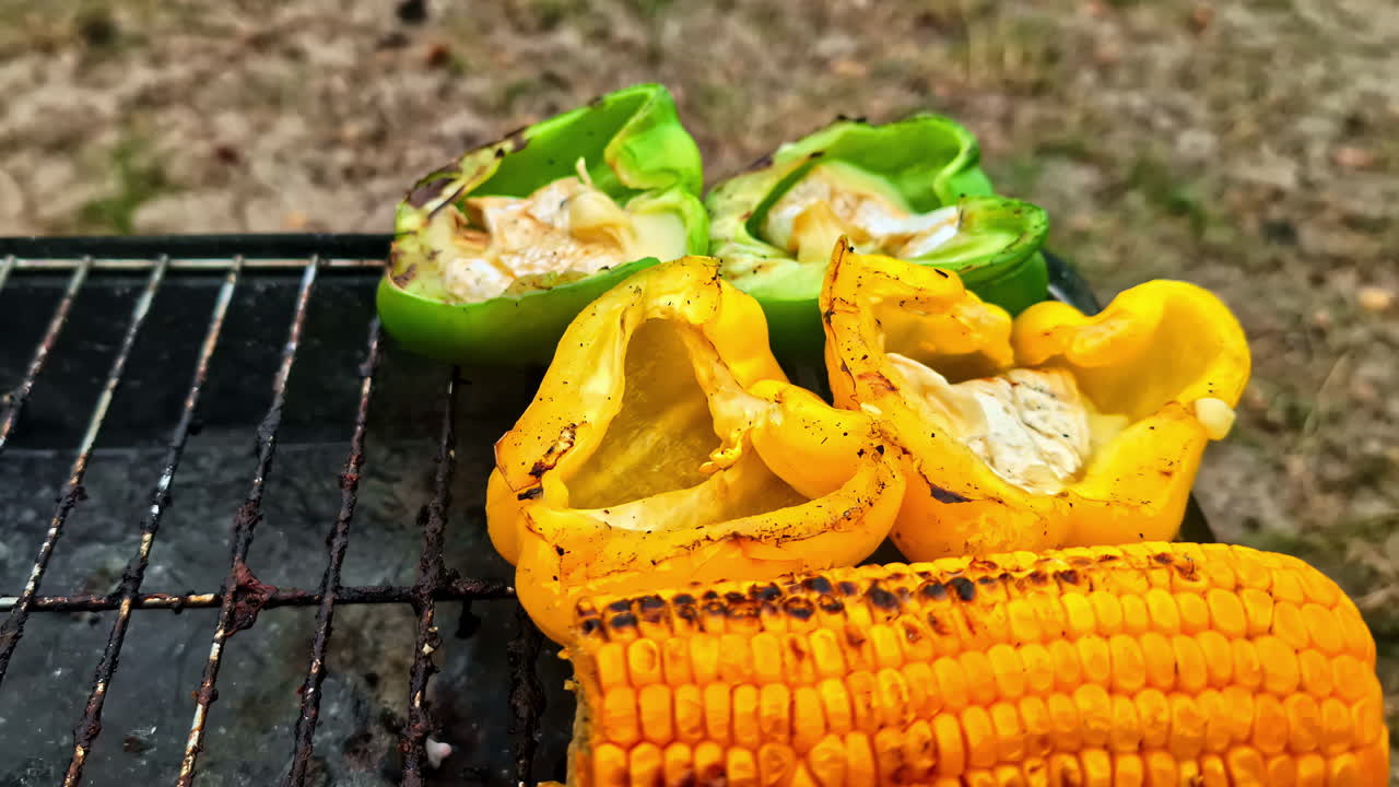 Closeup view of bellpapers along with corn on griller