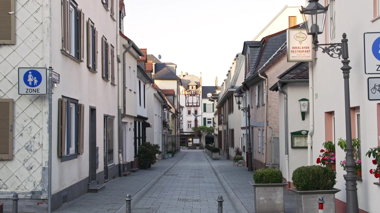 Smukt sommer eftermiddagsbillede af en katedral midt i en historisk gammel landsby nær Frankfurt i Tyskland. Kirken ligger i et kvarter med europæisk arkitektur, en populær turistattraktion.