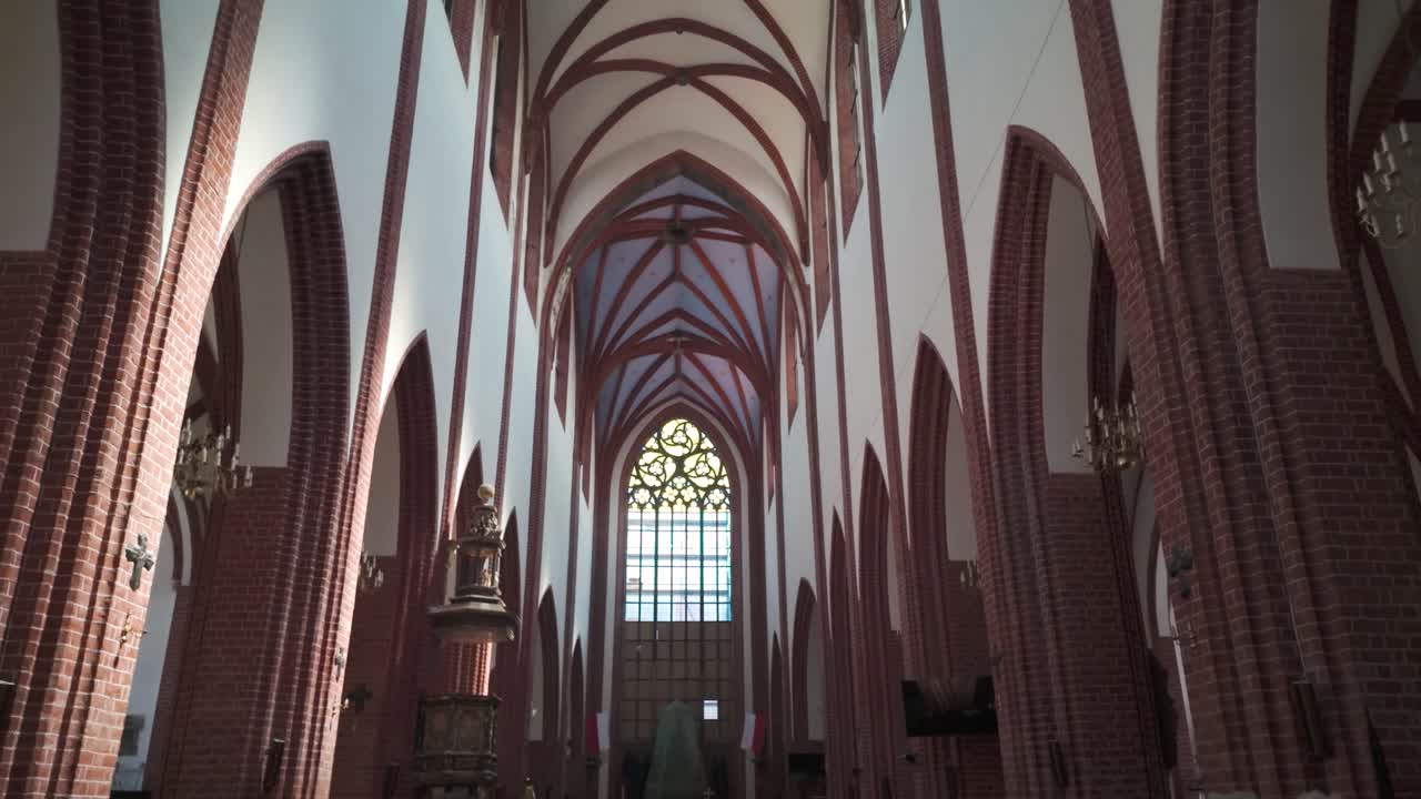 View of the impressive high ceiling architecture inside the Cathedral of St. Mary Magdalene, showcasing Gothic elements and intricate stained glass windows.