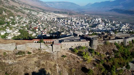 side view aerial of ancient gjirokster castle in albania during sunrise