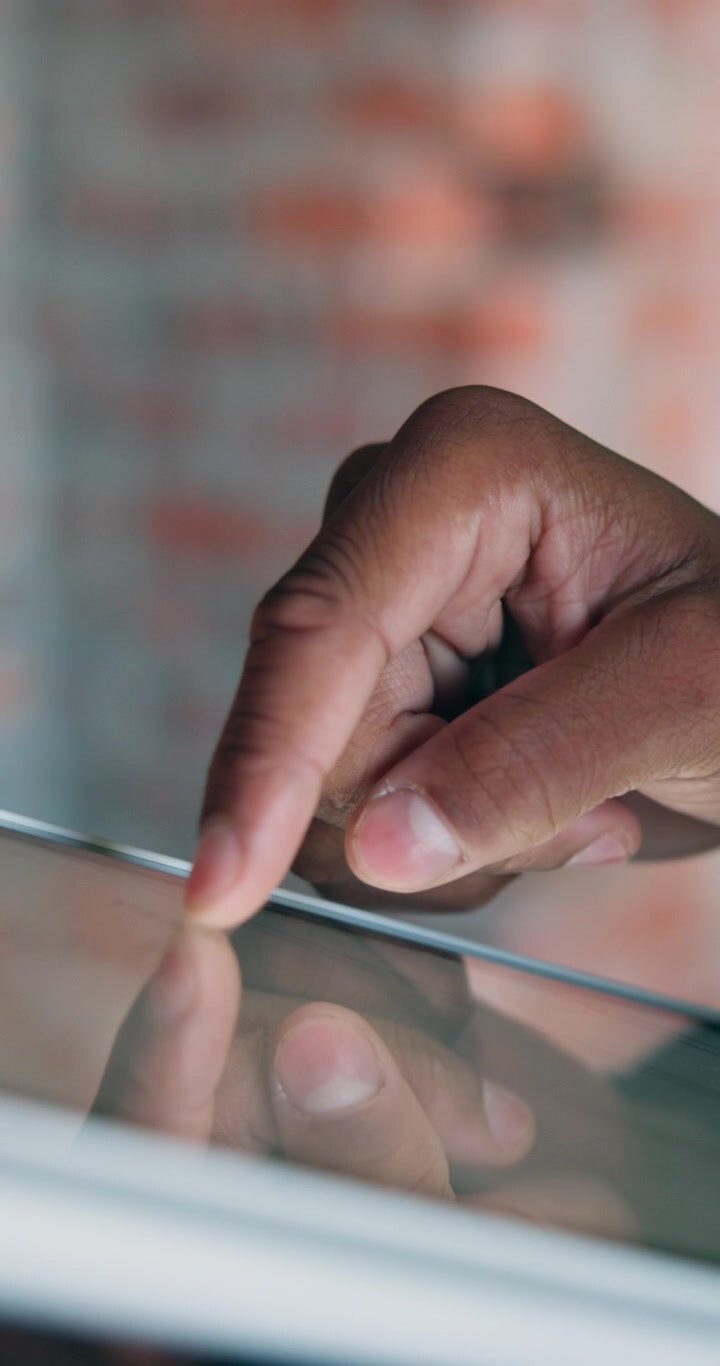 Close-up of Person Using Tablet Touchscreen
