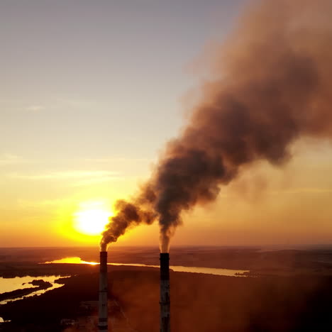 air pollution over power plant at sunset. violation of environmental contamination of the atmosphere the remnants of combustion near the evening river.
