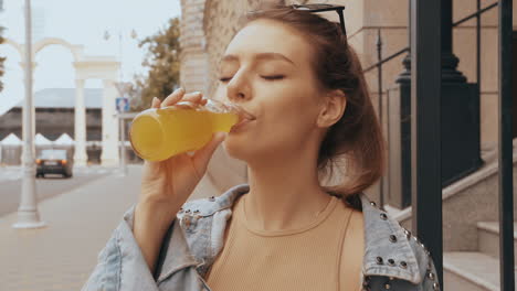 joven disfrutando de una bebida en la ciudad