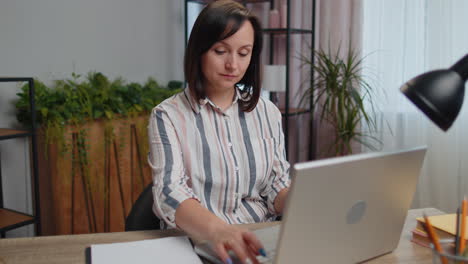 Young-business-woman-works-on-laptop-makes-online-purchases,-study,-e-learning,-remote-job-at-office