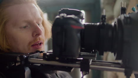 close up view of a redhead cameraman recording a scene in a ruined building 1