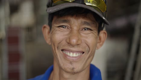 close-up portrait of a smiling man wearing a cap and sunglasses