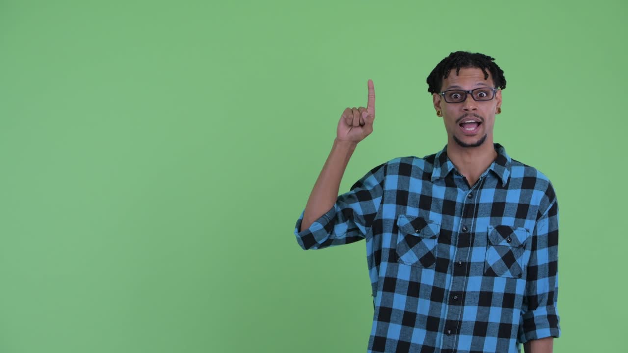 Giovane e bel uomo hipster africano felice che mostra qualcosa