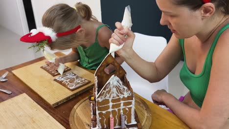 family decorating a gingerbread house