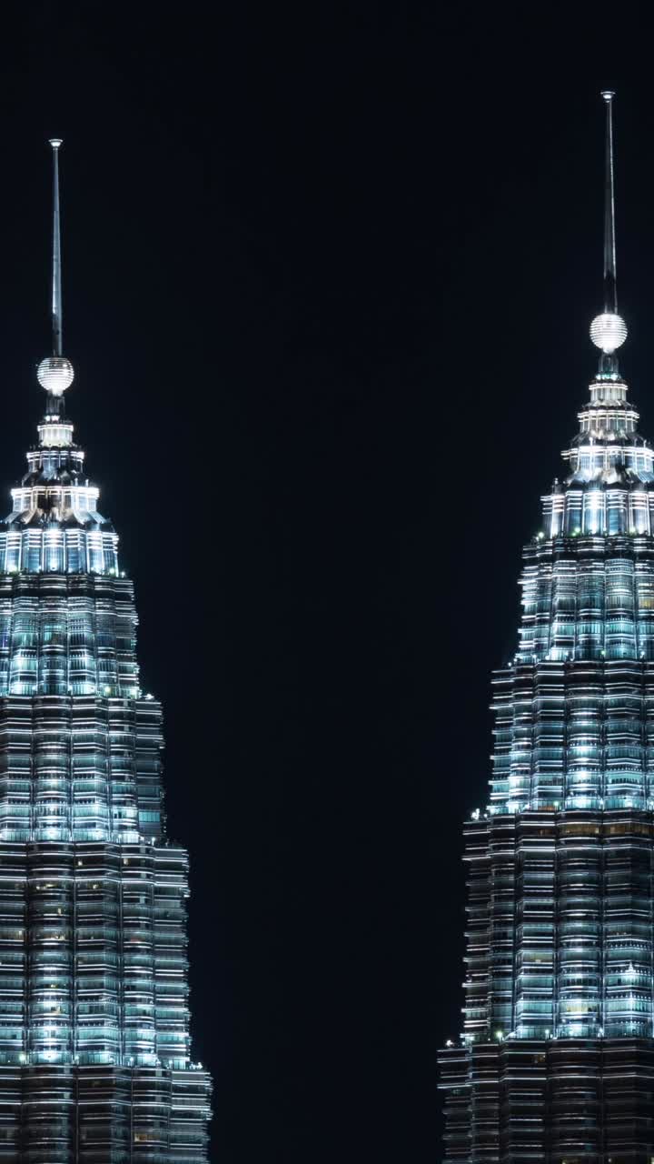 Torres Gemelas Petronas iluminándose por la noche en Kuala Lumpur
