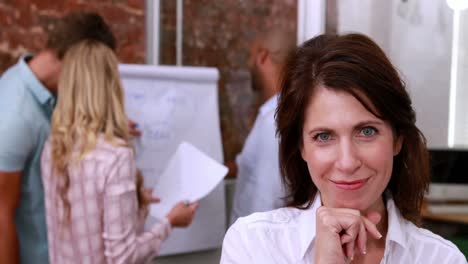 mujer de negocios casual sonriendo a la cámara durante una reunión