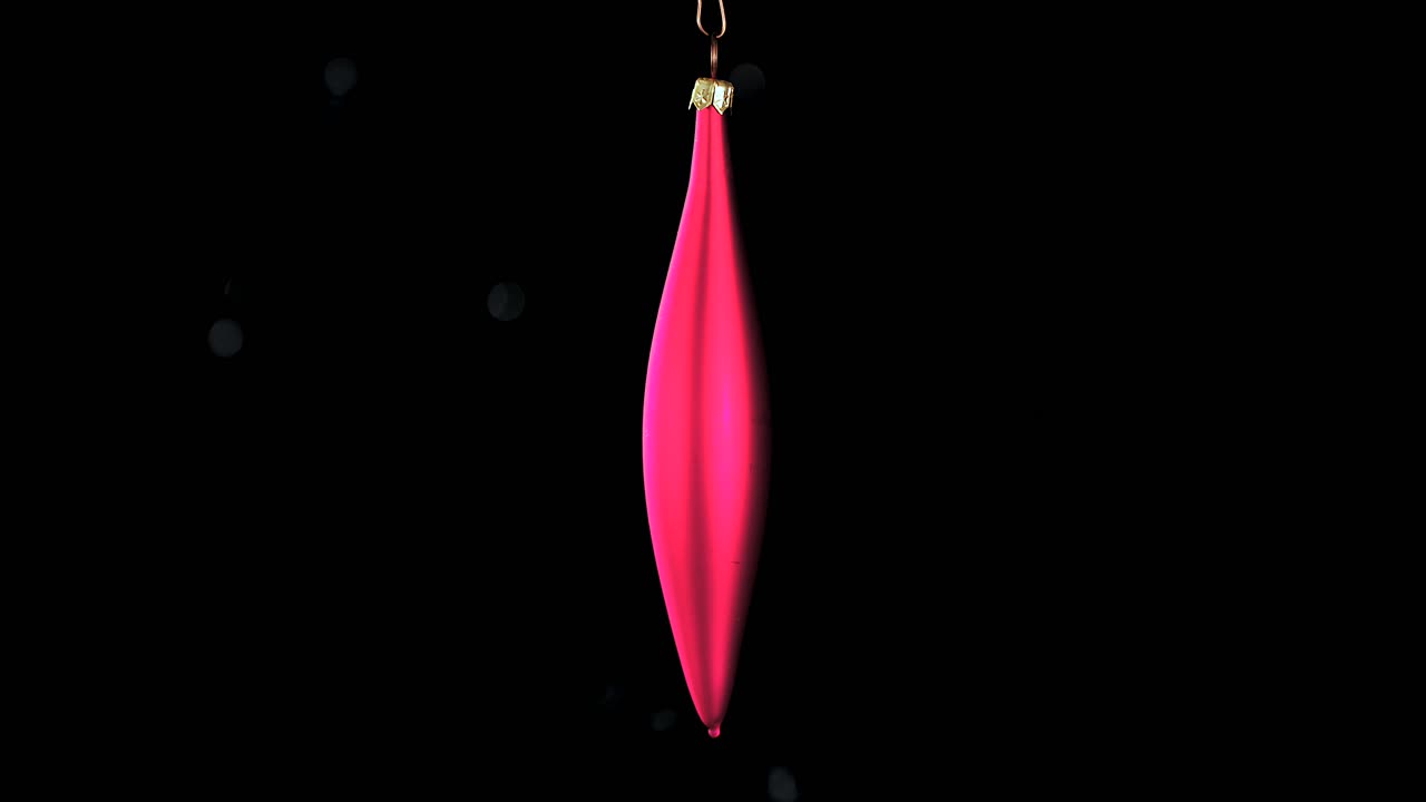 single red Christmas cone ornament with black background, close up