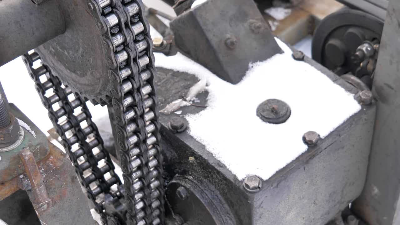 Close-up shot of steel conveyor system for ice blocks double strand roller chain at Harbin Ice Festival in Harbin, Heilongjiang, China