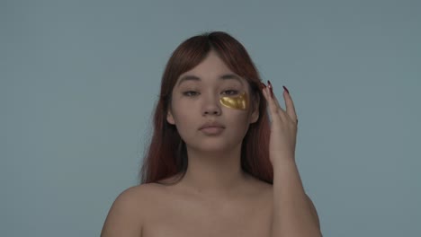 woman applying gold eye patches
