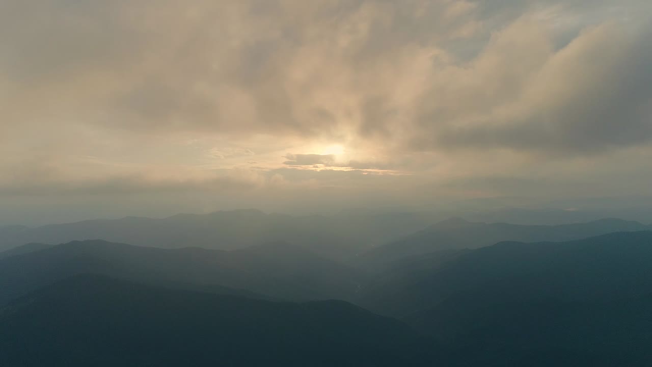 해가 지는 배경에서 산 위의 구름 속에서 날아가는 하이퍼스