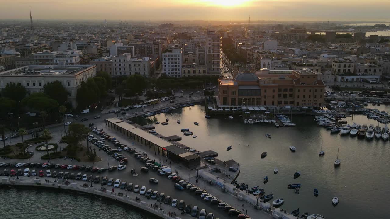 Aerial drone beautiful hyperlapse of sunset over Bari in Italy. Dock with boats.