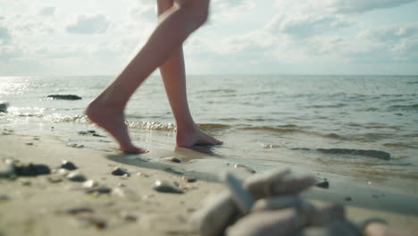 Barefoot women walk in to the sea on a sunny day, Sandvik, &Ouml;land Sweden , close up wide