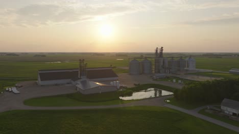 fertilizer and grain bins in minnesota during sunset. - aerial shot
