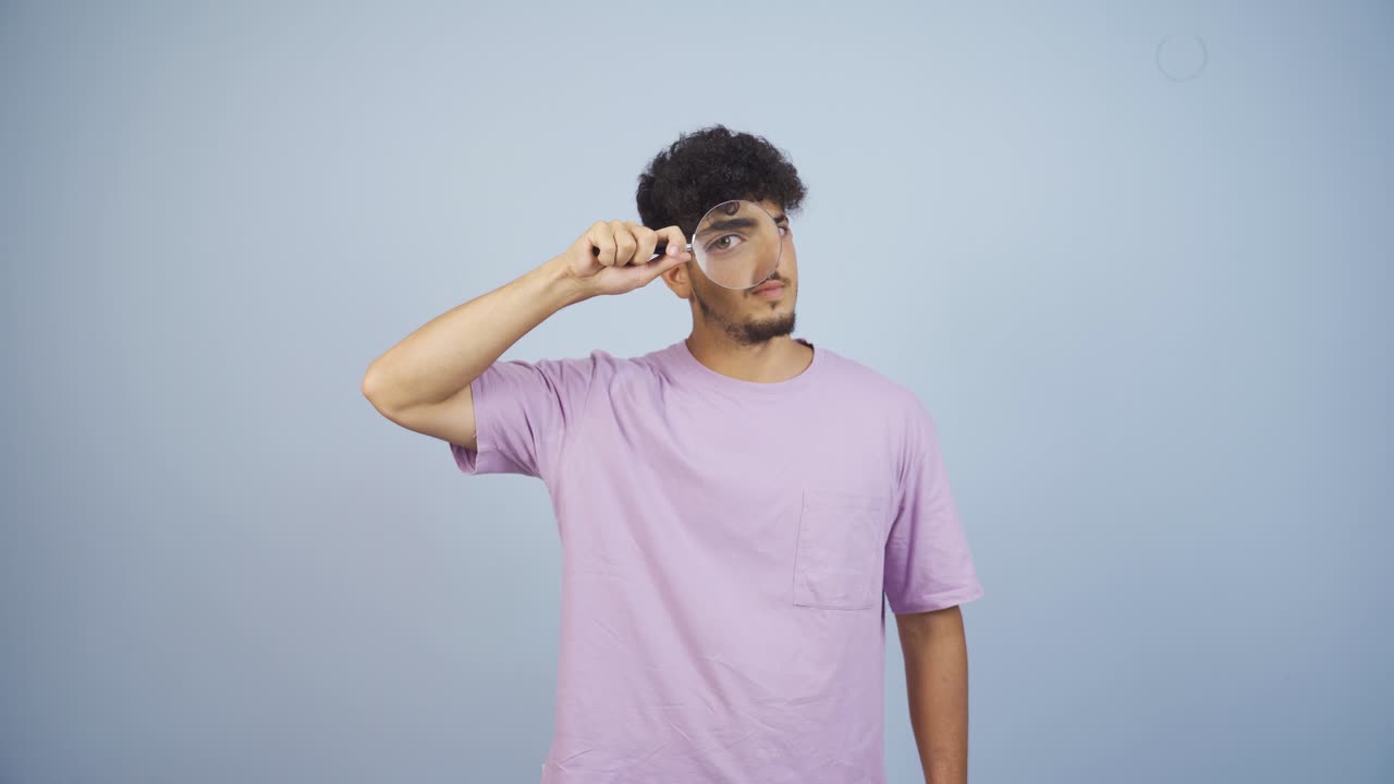 Man looking at camera with magnifying glass.