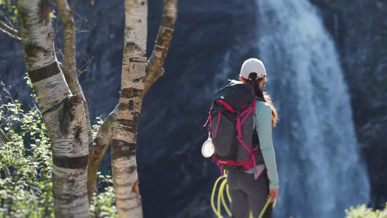 Une randonneuse debout au bout du sentier rocheux.