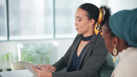 businesswomen collaborating with tablet in office meeting