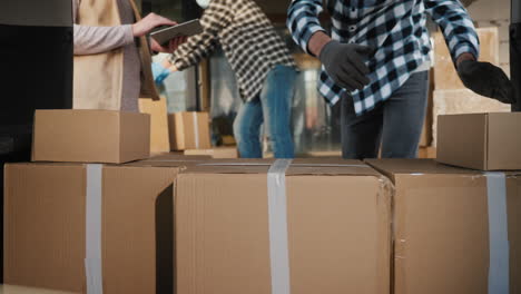 Delivery Workers Load Boxes Into The Trunk Of A Car