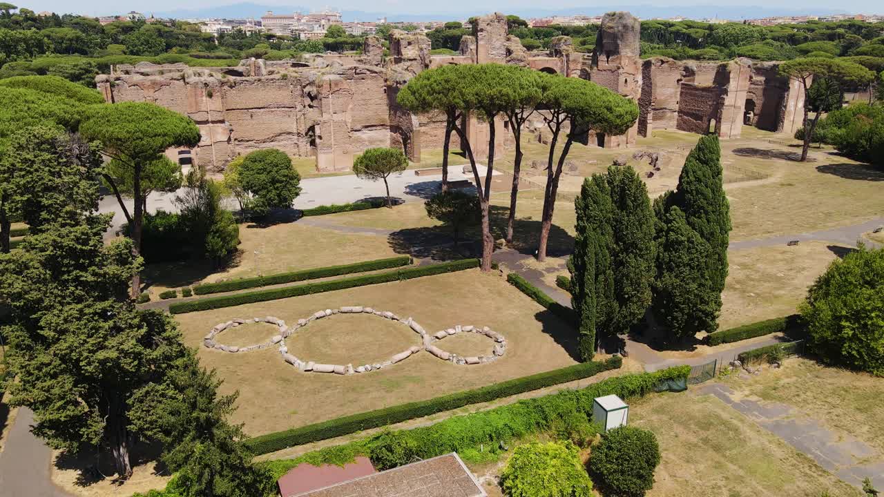 Drone of Baths of Caracalla ruins in Rome, lush summer greenery and blue skies