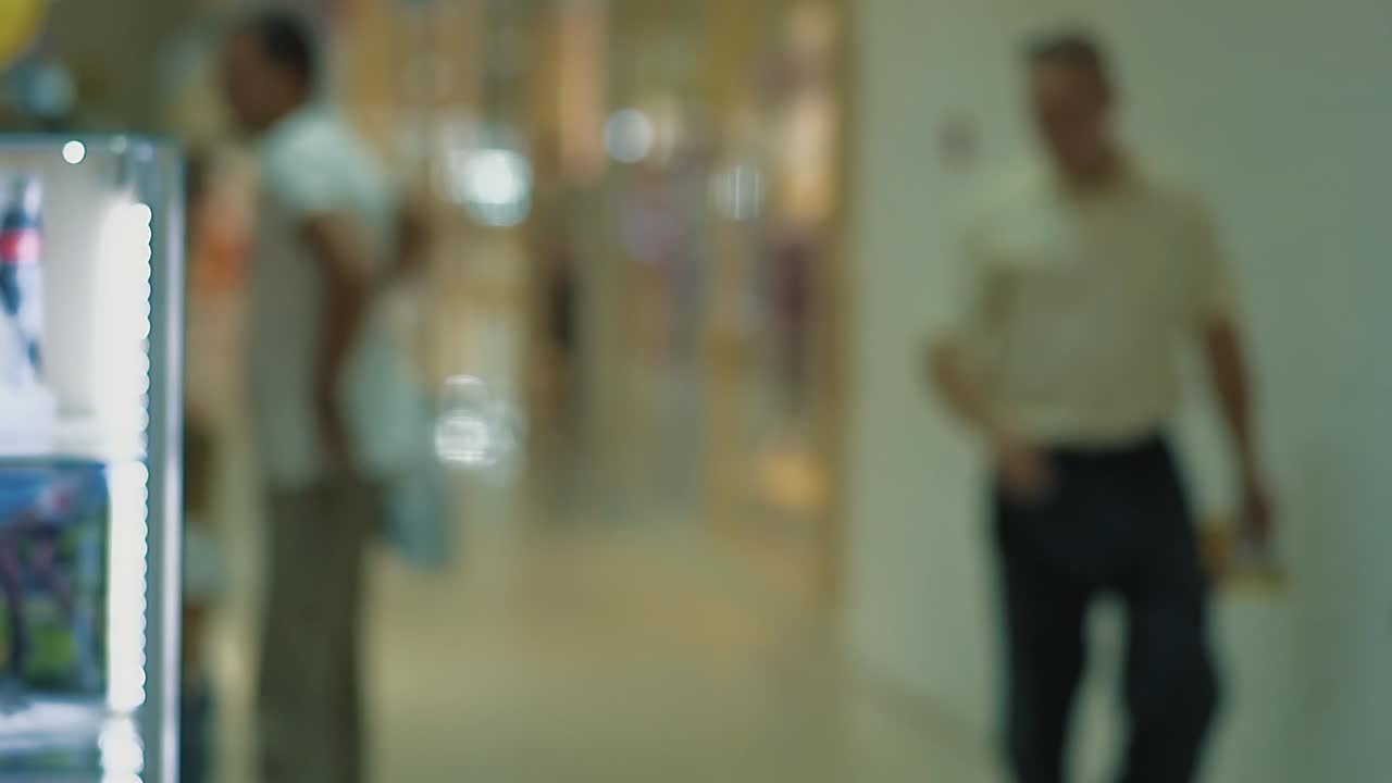 4 명의 사람들이 쇼핑 센터를 돌아다니고 있습니다.