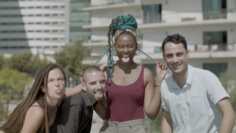 front view of happy employees sticking out tongues at camera