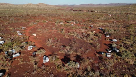 aerial tilt down shot over dales campsite in red desert of karijini national park at sunny day in australia