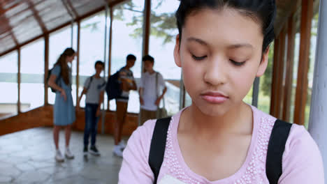 school friends bullying a sad girl in corridor