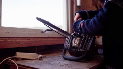 The-Man-is-Repairing-His-Chainsaw-For-Use-in-Cutting-Firewood-During-the-Winter-Season-in-Indre-Fosen,-Trondelag-County,-Norway---Close-Up