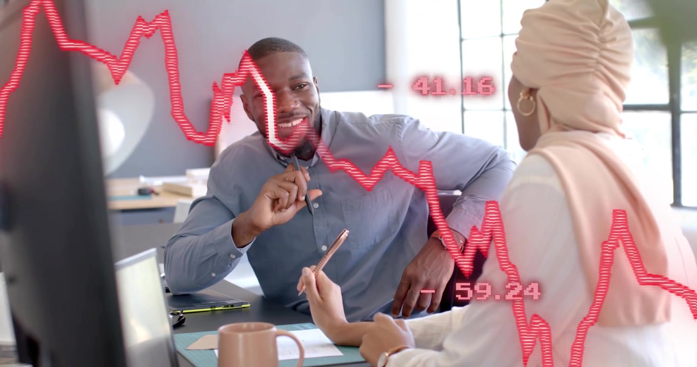 Woman pointing at red line graph appearing onscreen as man noting figures planning finance strategy
