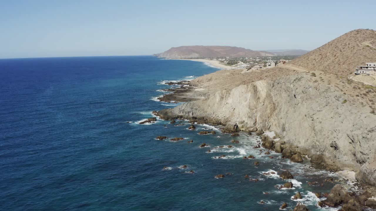 toma cinematográfica súper genial de los acantilados cerca de la playa de los cerritos en un día soleado con las olas de agua azul rompiendo las rocas en méxico