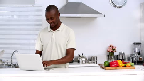 Hombre-Con-Laptop-En-Una-Cocina