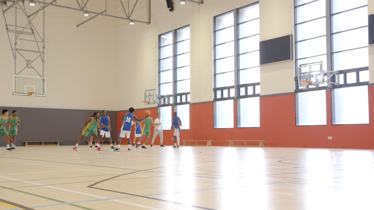 Basketbal spelen in de schoolgymzaal, studenten oefenen het spel op een binnenbaan.
