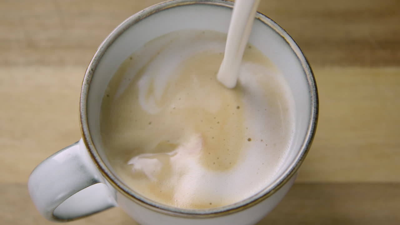 ZOOM IN creamy frothy oat milk finishes a cappuccino, 60fps