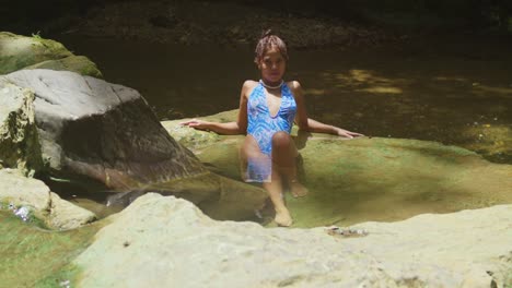 A-young-girl-in-a-bikini-experiences-the-waterfall-and-river-on-Trinidad