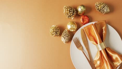 video of plate with cutlery and autumn decoration with leaves on yellow surface