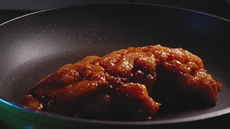 adding chicken breast to a frying pan - close-up view