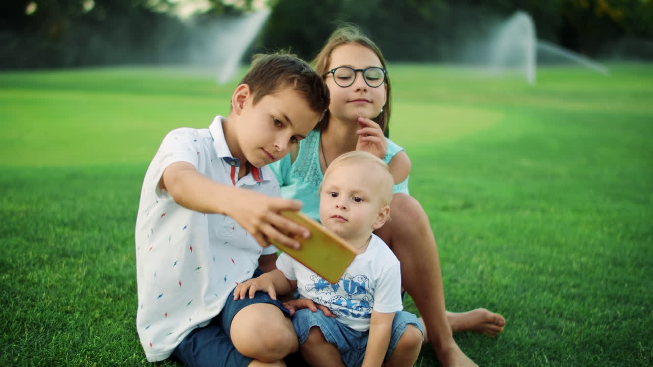niños tomando selfies con teléfonos inteligentes en el campo