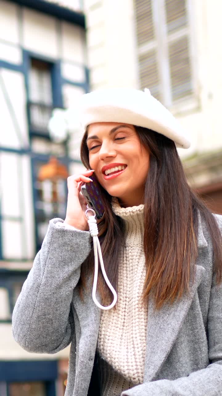 Woman in Beret and Coat Using Phone on City Street