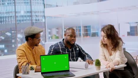 Personas-Diversas-Reunidas-En-Un-Recorrido-Por-La-Oficina-Junto-A-Una-Computadora-Portátil-Con-Pantalla-Verde