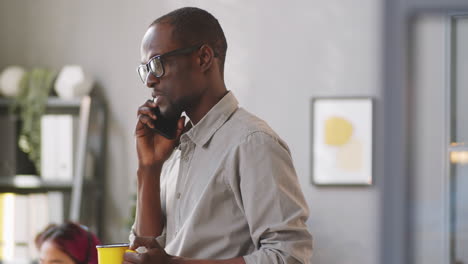 Afroamerikanischer-Mann,-Der-Im-Büro-Auf-Dem-Mobiltelefon-Spricht