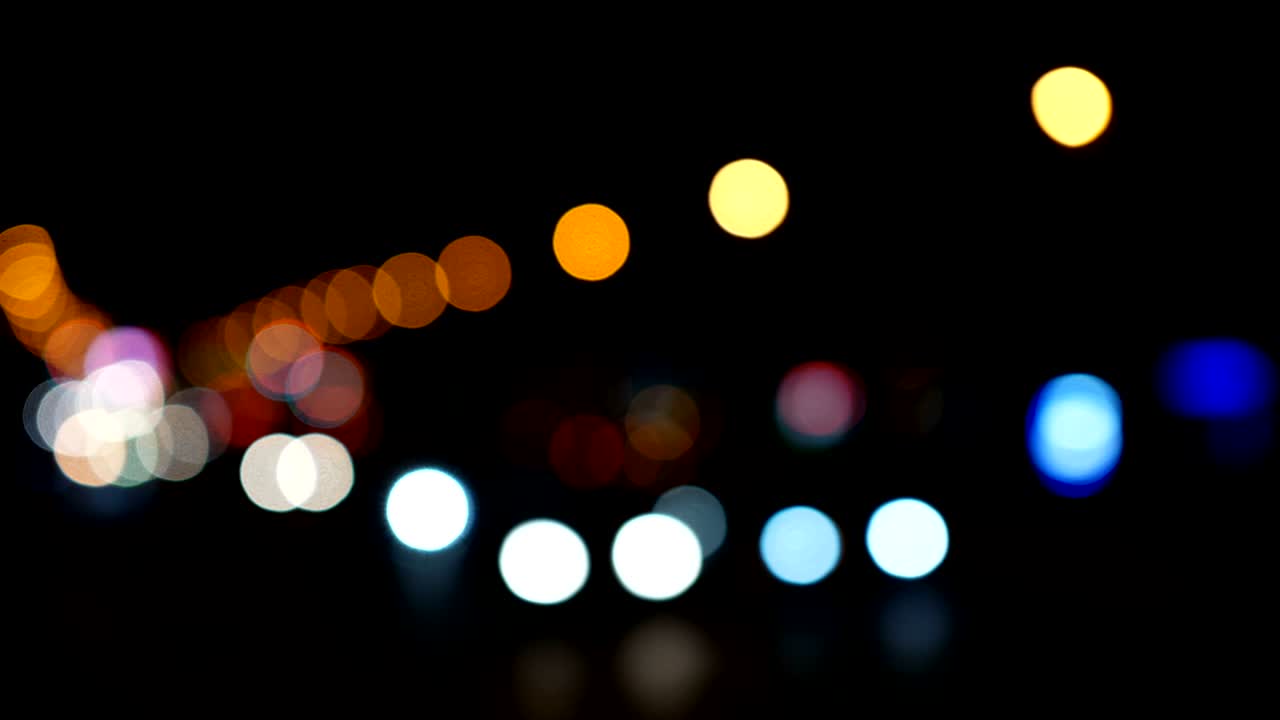 luces desenfocadas calle de los ángeles resumen. fondo borroso de la ciudad. círculos de bokeh en movimiento del tráfico nocturno.