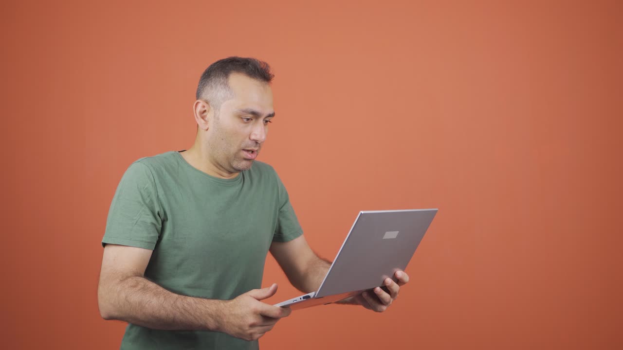 hombre de negocios mirando la computadora portátil con expresión asustada.