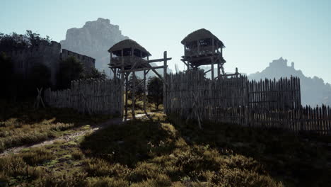 medieval palisade gate with watchtowers and mountain view