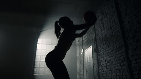 athlete throwing heavy ball against wall. woman practicing physical exercises