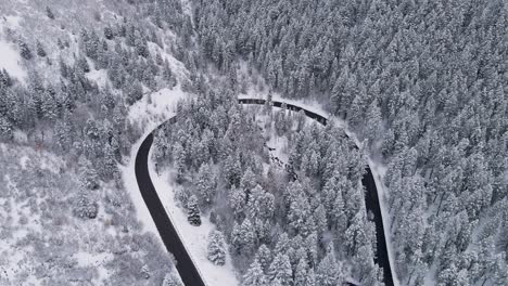 Vista-Aérea-De-La-Ruta-Escénica-Alpine-Loop-Que-Serpentea-A-Través-Del-Paisaje-Invernal-En-El-Cañón-American-Fork-En-Las-Montañas-Wasatch,-Utah