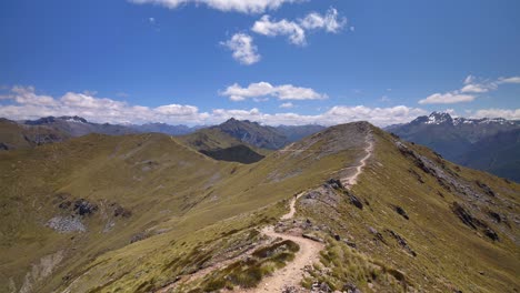 Static,-distant-hiker-on-exposed-trail,-vast-mountain-landscape,-Fiordland,-Kepler-Track-New-Zealand